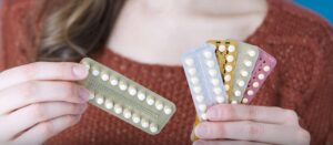 mulher com diversos tipos de pilulas anticoncepcional na mão